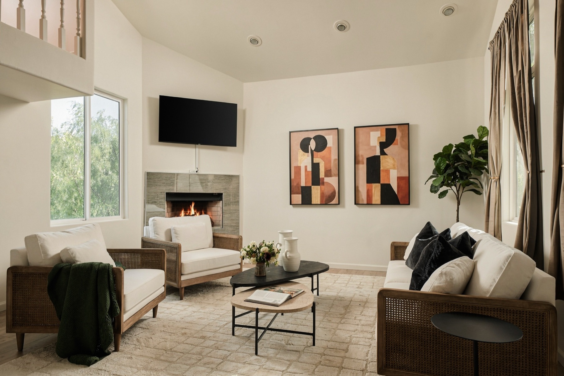 Vaulted living room with fireplace and tall windows