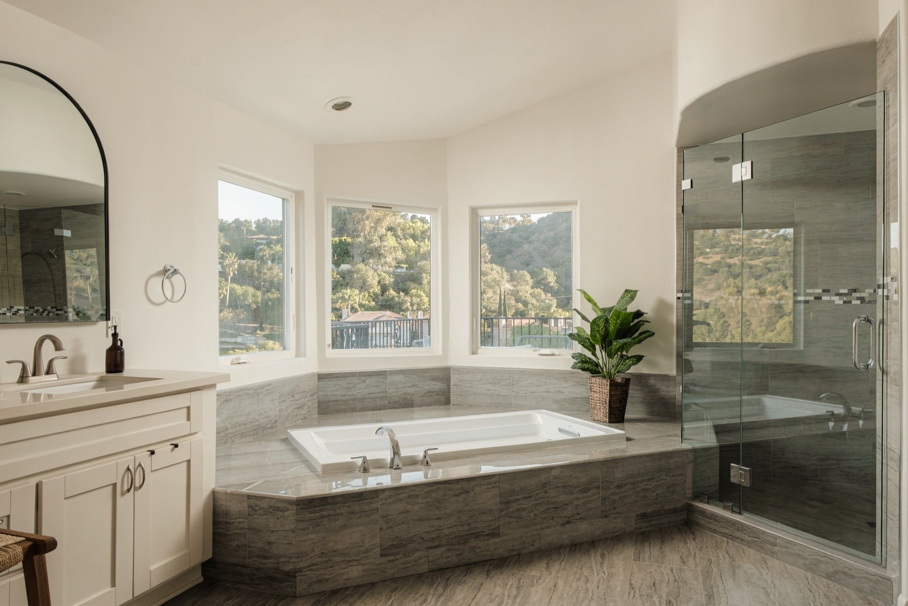 Primary bath with the tub, shower, and view windows