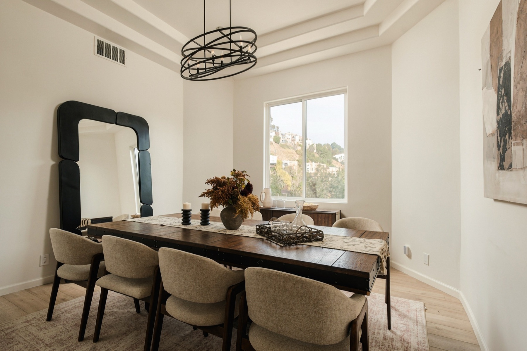 Dining room with a large mirror and a ring chandelier